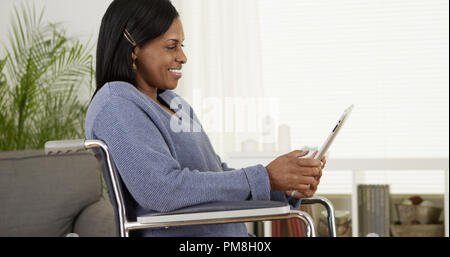 Handicap schwarze Frau mit einem Tablet Stockfoto