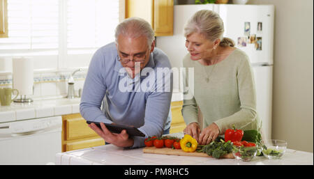 Senior Paar mit Tablet und Kochen Stockfoto