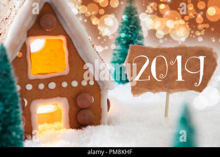 Lebkuchenhaus in der verschneiten Landschaft als Weihnachtsdekoration. Weihnachtsbäume und Kerzen für romantische Atmosphäre. Bronze- und orangefarbenen Hintergrund mit Stockfoto