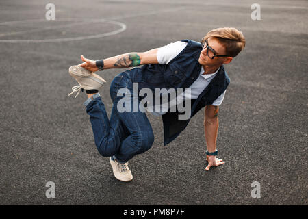 Jungen gutaussehenden Mann im stilvollen Denim Kleid tanzen hip hop Stockfoto