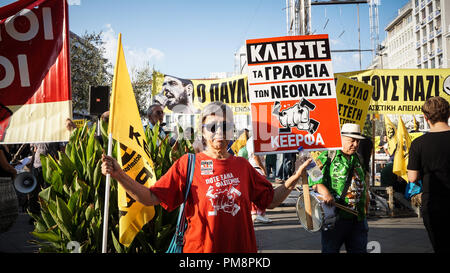 Eine Frau gesehen, eine Flagge und ein Poster während des Protestes. Tausende Demonstranten nahmen die Straßen gegen Faschismus und Rassismus in Athen. Der März war vor allem auf den Mord an dem Rapper Pavlos Fyssas konzentriert, von einem Neonazi im Stadtzentrum von Piräus vor ein paar Jahren. Stockfoto