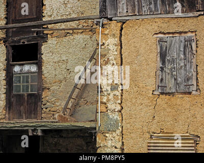 Braun in maroden Fenster und Rollläden in abgenutzt aus Stein und Holz Gebäude im Ariège Pyrenäen, Frankreich Stockfoto