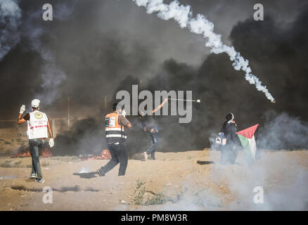 Ein palästinensischer Mann mit einer Schleuder Steine gegen israelische Truppen während der Auseinandersetzungen zu werfen. Auseinandersetzungen zwischen palästinensischen Demonstranten und israelischen Kräfte während eines Protestes entlang der israelischen Zaun östlich von Gaza-stadt. Stockfoto