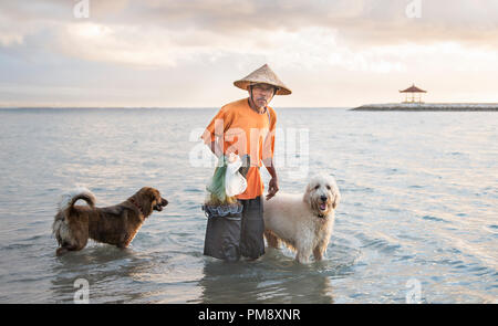 Bali, Indonesien, 11. September 2016: Old Fisherman mit Hunden Stockfoto