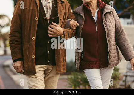 Nahaufnahme von Senior Paar Hände halten und zusammen gehen im Freien. Mittelteil der alten Paar Hand in Hand im Freien. Stockfoto