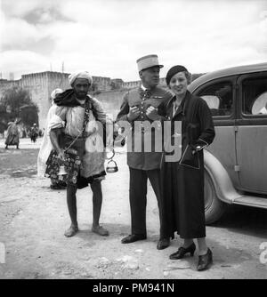 Marokko 1930 Französische Fremdenlegion Soldat und elegant gekleidete Frau mit lokalen Mann Verkauf von Waren Stockfoto