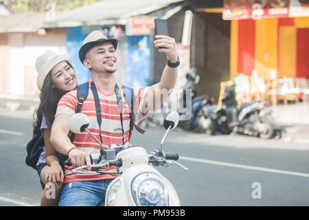 Zwei junge Rucksacktouristen, die selfies mit Handys Kamera w Stockfoto