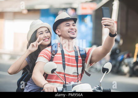 Zwei junge Rucksacktouristen, die selfies mit Handys Kamera w Stockfoto