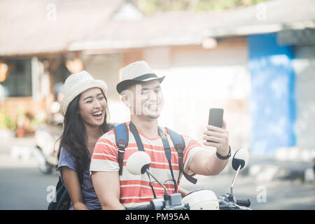 Zwei junge Rucksacktouristen, die selfies mit Handys Kamera w Stockfoto