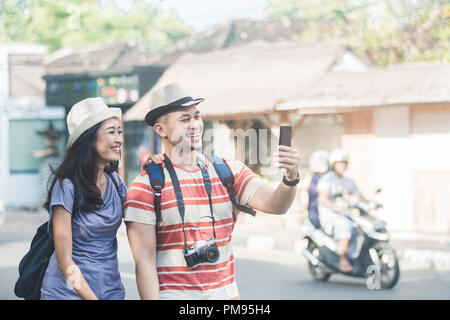 Zwei junge Rucksacktouristen, die selfies Handys mit Kamera Stockfoto