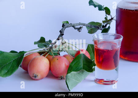 Wilde Äpfel mit lebendigen Farben auf einem Zweig und hausgemachte Marmelade auf weißem Hintergrund Stockfoto