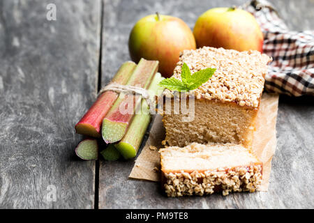 Hausgemachten Rhabarber und Apfelkuchen mit Gezuckerter Hafer auf hölzernen Tisch lagen Stockfoto