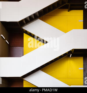 Moderne Treppen im Zickzack gegen eine gelbe Wand im Atrium der in einem modernen Gebäude in der Stadt. Zeitgenössischen/modernen Architektur & Design Stockfoto