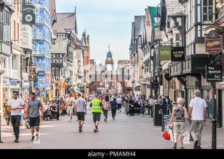 Chester, England - 16. August 2016: Käufer wandern in Eastgate Street. Die Uhr der Überbrückung der Straße ist wie das Eastgate clock bekannt. Stockfoto