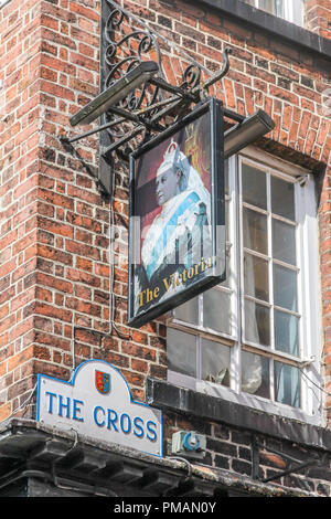 Chester, England - 16. August 2016: Zeichen für die Victoria Public House und Straßenschild für das Kreuz. Es ist ein traditioneller englischer Pub. Stockfoto