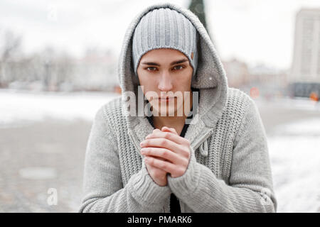 Hübscher junger Mann aus Gewirken Kleider in einem kalten Wintertag. Stockfoto