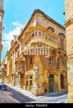 Die nische Statue des heiligen Roque in der Ecke des historischen Gebäude in St. Christophorus und St. Ursula Straßen Kreuzung, Valletta, Malta. Stockfoto