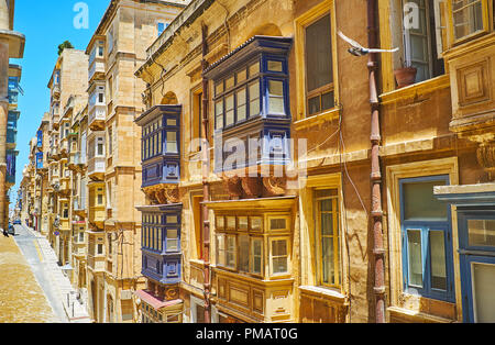 Die dichten Gebäuden entlang des hl. Dominikus Straße mit typischen hölzernen Maltesischen Balkone - die Visitenkarte der lokalen Architektur, Valletta, Malta. Stockfoto