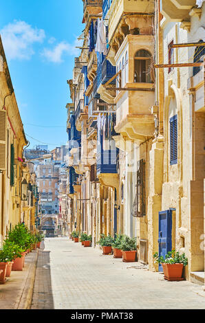 Gehen Sie die East Street, mit alten Wohnhäusern gesäumt und mit Pflanzen in Töpfen, Valletta, Malta eingerichtet. Stockfoto