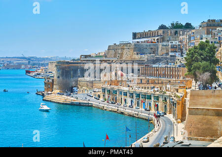 Die Festungsmauern von Valletta öffnen Sie den perfekten Blick auf Steinbruch Wharf mit mittelalterlichen Gebäuden, Wällen, Bastionen und Boote im Hafen, Valletta, Malta Stockfoto