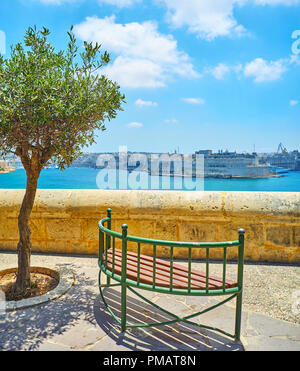 Die kleine Bank, auf der Sicht Terrasse der unteren Barrakka Gärten mit Blick auf Fort St. Angelo in Birgu, hinter dem azurblauen Wasser von Valletta Gran Stockfoto