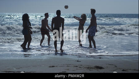 Silhouette der Gruppe von interracial Freunden Volleyball im Wasser am Strand Stockfoto
