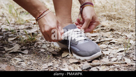 Aktive passende Frau binden Schuh im Park Stockfoto