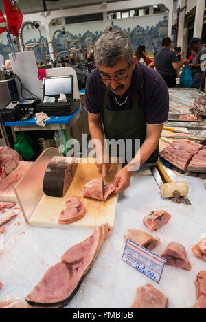 Fischverkäufer, der Schwertfisch für den Verkauf vorbereitet. Indoor-Marktplatz in Setubal, Portugal, Europa. Stockfoto