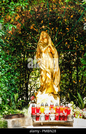 Die vergoldete Statue der Madonna vor der St. Jakobs Kirche in Opatija, Kroatien mit schönen Karteninhaber in rotem Glas Stockfoto