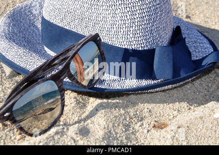 Sonnenbrille und Hut am Strand Stockfoto