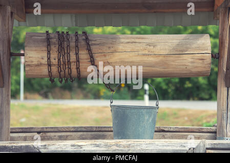 Die alten Brunnen für Wasser mit einem Deck, eine Schaufel und eine Kette, Stockfoto