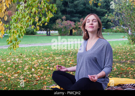 Schwangere Frau ruht in einem Herbst Park. Meditation und Entspannung Stockfoto