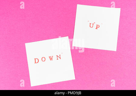 Der Kontrast zwischen der nach oben und unten Wörter auf zwei Blatt Papier gedruckt Stockfoto