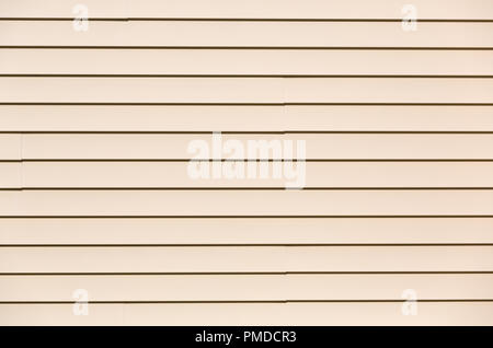 In der breiten Ansicht der Zeilen von beige Vinyl Siding in strahlendem Sonnenschein. Stockfoto