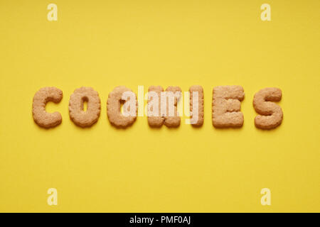 Cookies Wort heraus mit cookie Buchstaben oder Zeichen auf gelbem Papier Hintergrund geschrieben Stockfoto