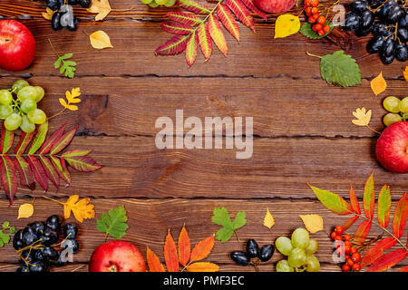 Herbst Hintergrund mit Gelb, mit hellen Blätter, Tannenzapfen, Kastanien und Beeren. Frame Herbst Ernte auf abgelagertem Holz mit freiem Speicherplatz. Die LAYOU Stockfoto