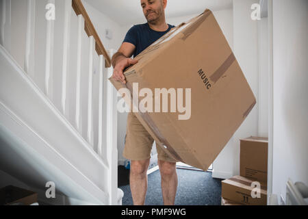 Reifer Mann bewegt Boxen von Hab und Gut in sein neues Zuhause. Stockfoto