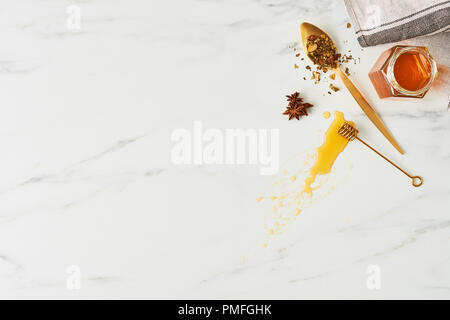 Honig Konzept. Blick von oben auf die Honig, goldenen Löffel mit Kräutern und Pendelarm mit Honig auf weißem Hintergrund. Flach mit kopieren. Stockfoto