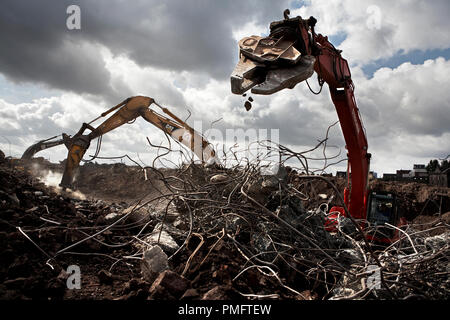 Wie Dinosauria, die Bagger arbeiten mit speziellen Greifer durch riesige Zelte aus Stahl Drähte, die während der Bauarbeiten auf dem Gelände der ehemaligen Phoenixstahlwerk in Dortmund Hoerde gesammelt wurden. Wo im Jahr 2003 die chinesischen Arbeiter eine komplette Stahl- und Walzwerk im Rekordtempo demontiert und in China wieder aufgebaut. Stockfoto