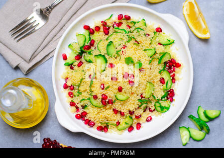 Couscous Salat mit Granatapfel, Minze und Gurken, gesunde Hausmannskost, vegane Mahlzeit Stockfoto