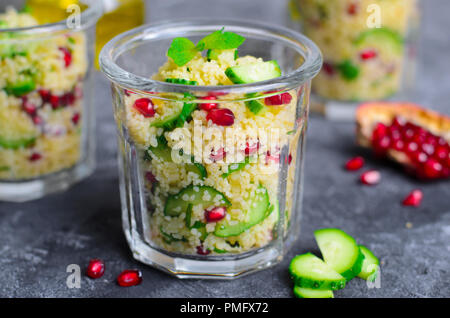 Couscous Salat in einem Glas mit Granatapfel, Minze und Gurken, gesunde Hausmannskost, vegane Mahlzeit Stockfoto