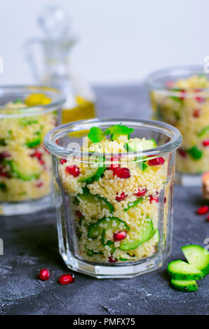 Couscous Salat in einem Glas mit Granatapfel, Minze und Gurken, gesunde Hausmannskost, vegane Mahlzeit Stockfoto