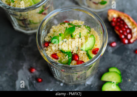 Couscous Salat in einem Glas mit Granatapfel, Minze und Gurken, gesunde Hausmannskost, vegane Mahlzeit Stockfoto
