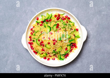 Couscous Salat mit Granatapfel, Minze und Gurken, gesunde Hausmannskost, vegane Mahlzeit Stockfoto