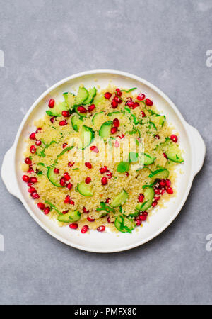 Couscous Salat mit Granatapfel, Minze und Gurken, gesunde Hausmannskost, vegane Mahlzeit Stockfoto