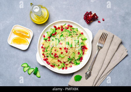 Couscous Salat mit Granatapfel, Minze und Gurken, gesunde Hausmannskost, vegane Mahlzeit Stockfoto