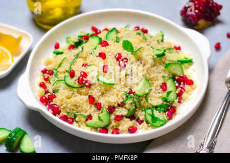 Couscous Salat mit Granatapfel, Minze und Gurken, gesunde Hausmannskost, vegane Mahlzeit Stockfoto