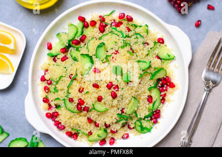Couscous Salat mit Granatapfel, Minze und Gurken, gesunde Hausmannskost, vegane Mahlzeit Stockfoto