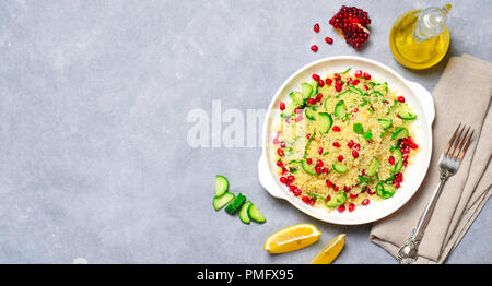 Couscous Salat mit Granatapfel, Minze und Gurken, gesunde Hausmannskost, vegane Mahlzeit Stockfoto