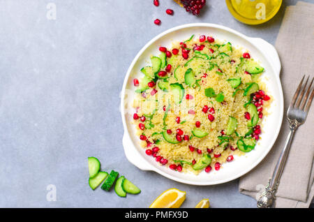 Couscous Salat mit Granatapfel, Minze und Gurken, gesunde Hausmannskost, vegane Mahlzeit Stockfoto